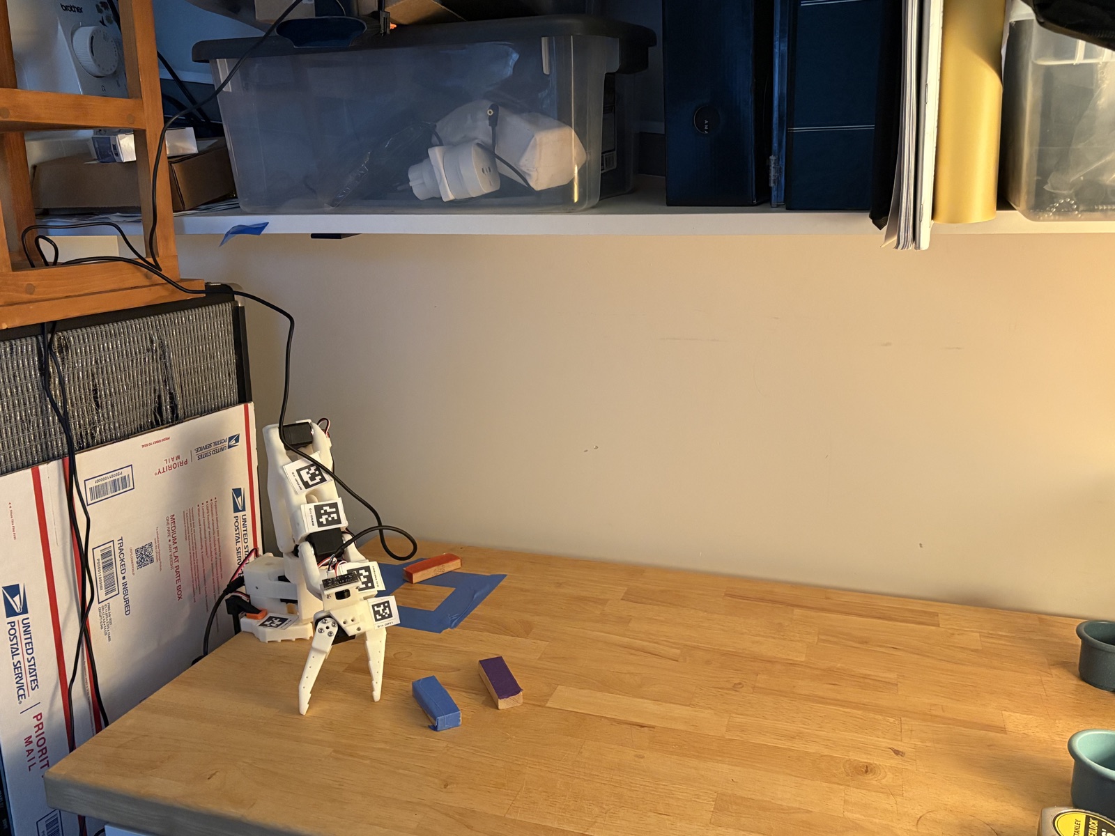 A LeRobot SO-101 arm and its overhead camera in a home robotics workspace.
