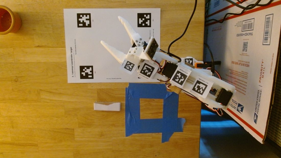 figure 3: The plan, in its optimistic phase. AprilTags on every link, a tag sheet on the table, fit the geometry, plan a grasp.